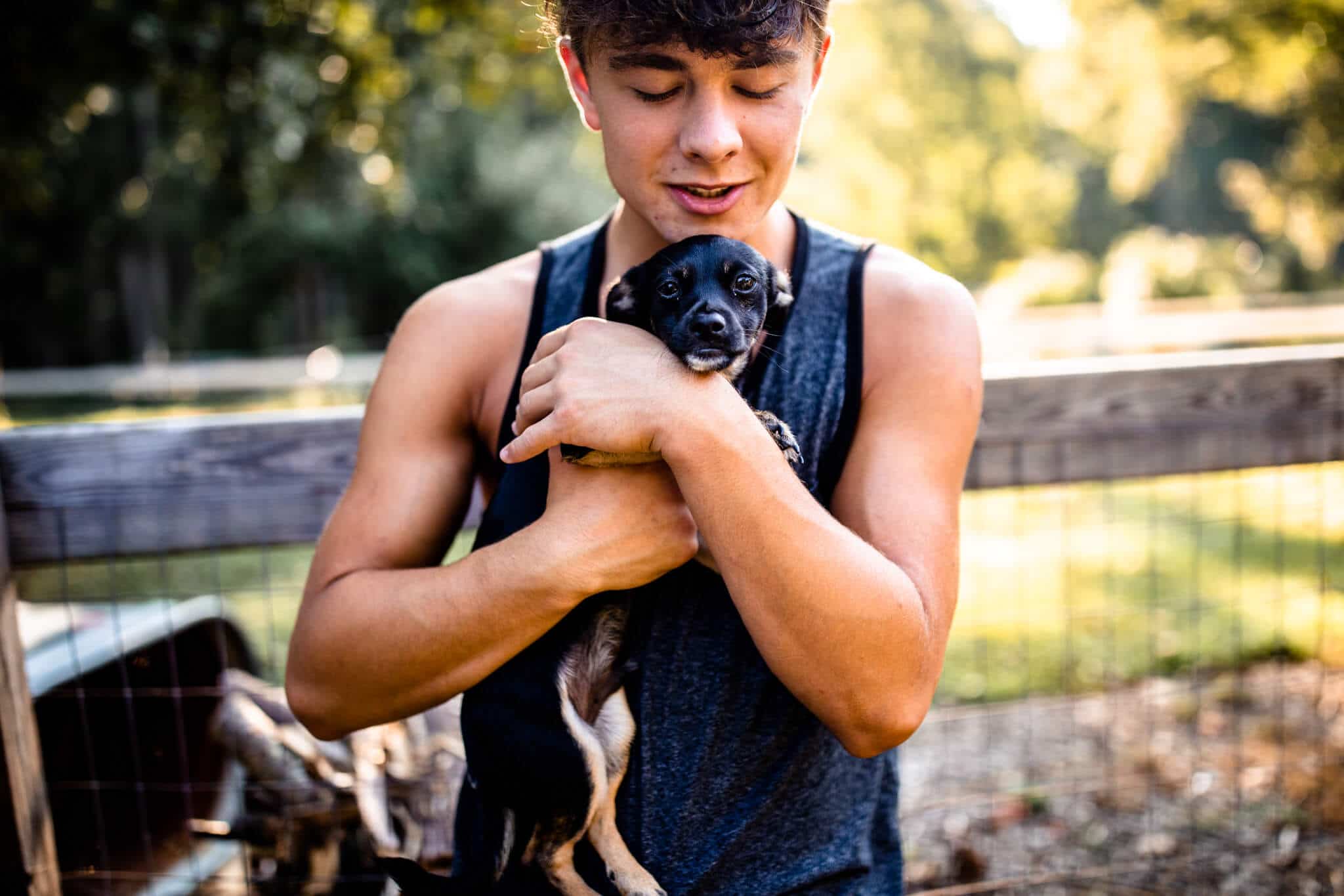 high school senior boy holds puppy