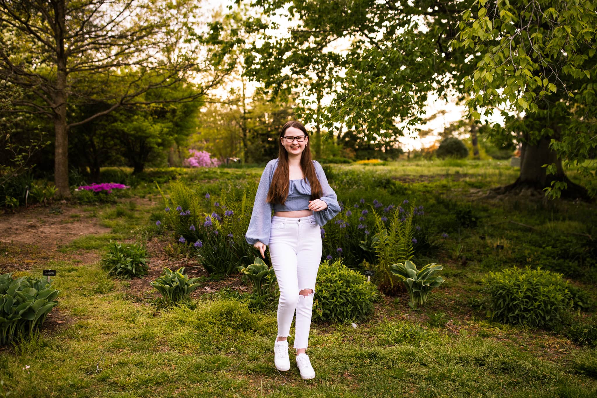 high school senior girl in gardens smiling and standing