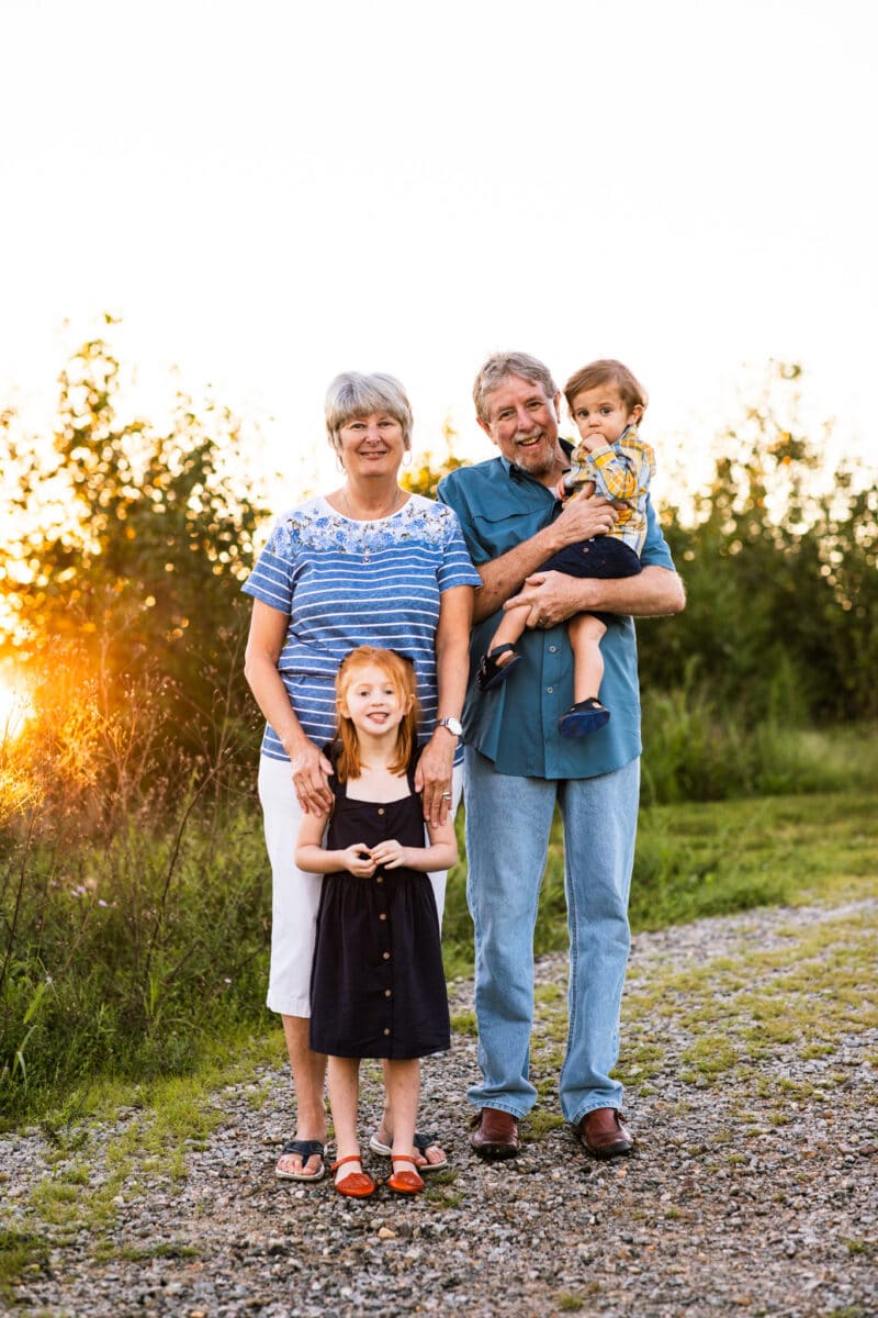 grandparents smiling with two grandkids at outdoor photography session