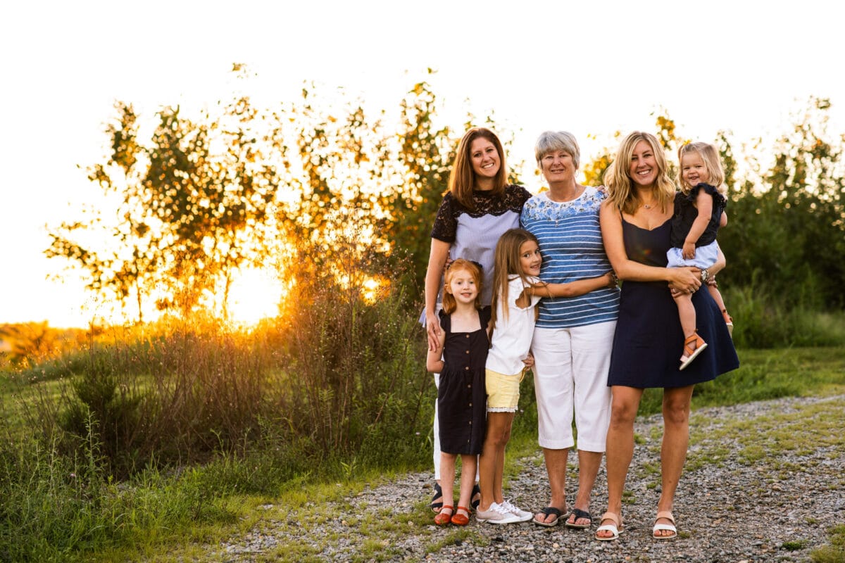 grandmother with daughters and grandkids smiling in field
