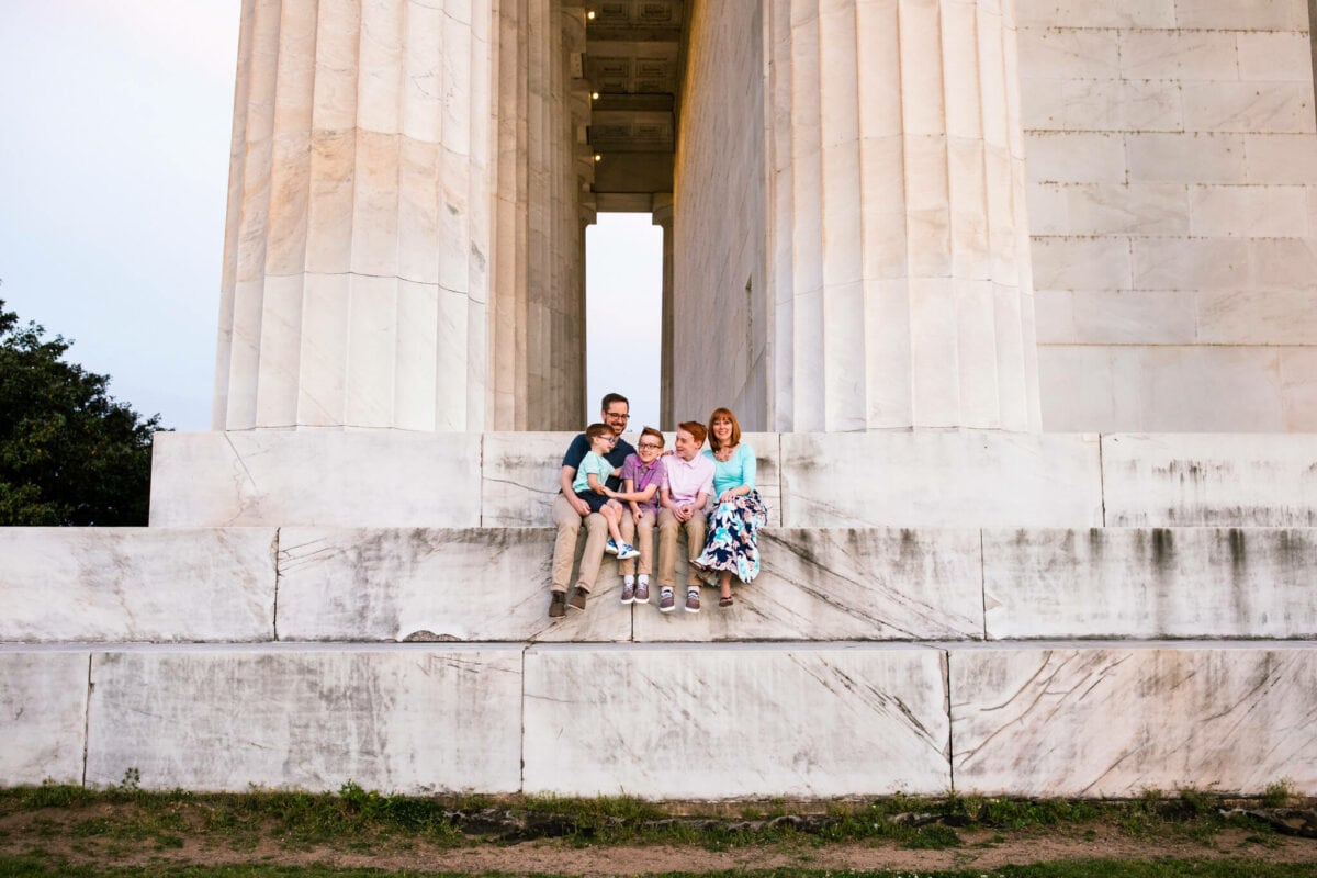family of 5 sitting on large steps of Lincoln Memorial DC
