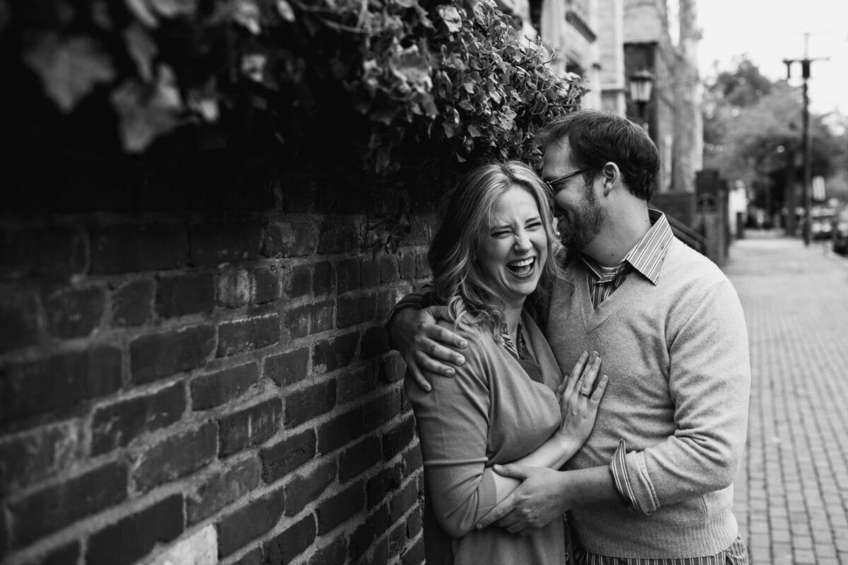 black and white image of a husband and wife hugging and laughing