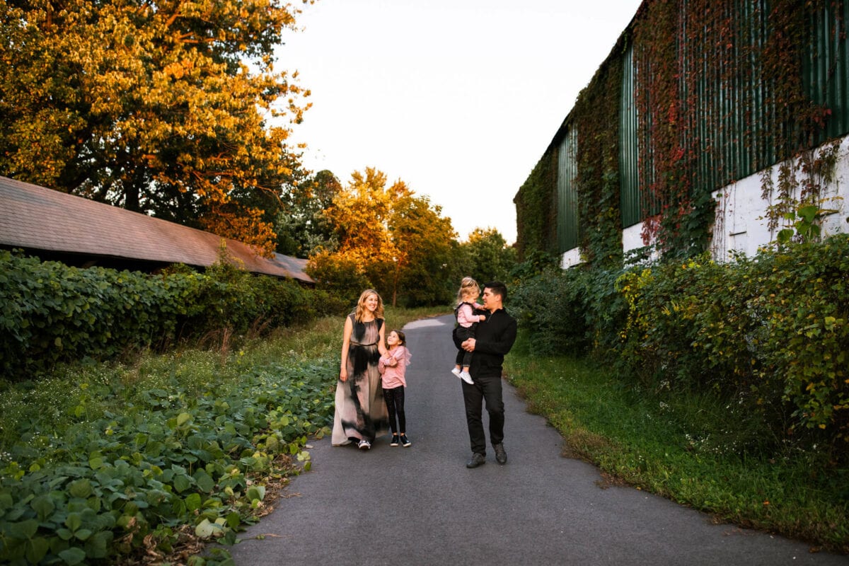 family walking towards camera in fall setting with old buildings