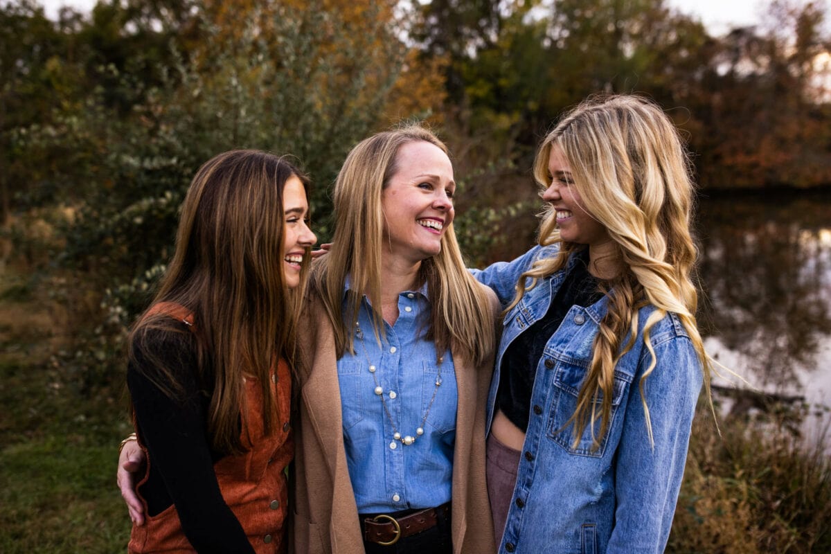 mom smiling with two teenage daughters
