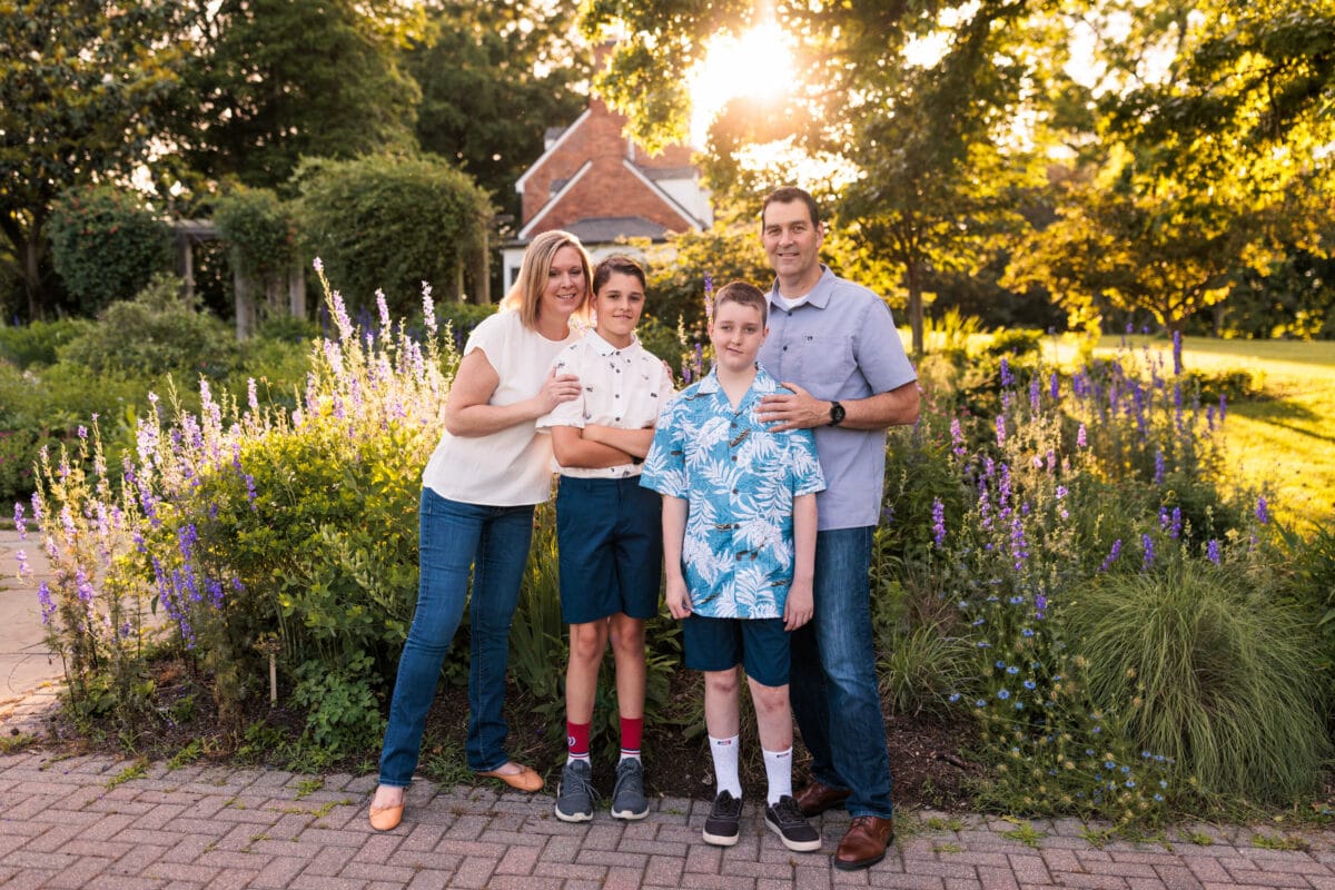 family standing near flowers with sun setting 2022 client superlative awards
