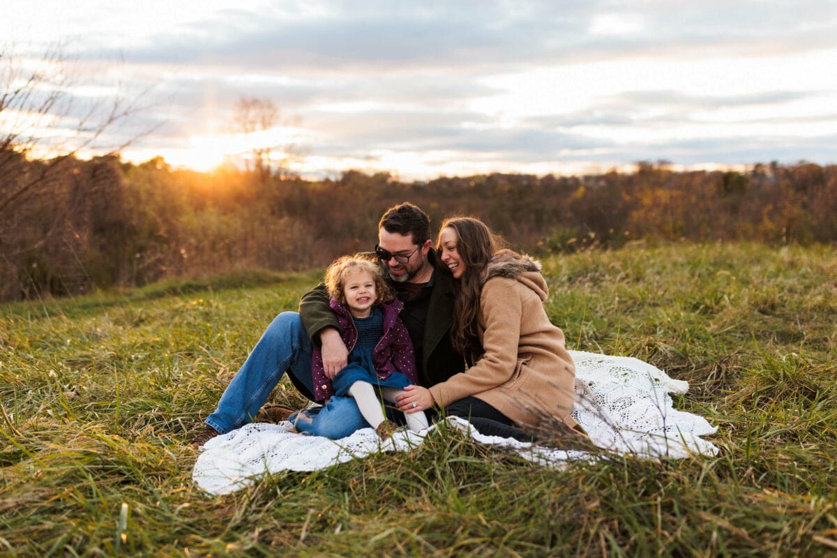family of 3 on blanket in open field 2022 client superlative awards
