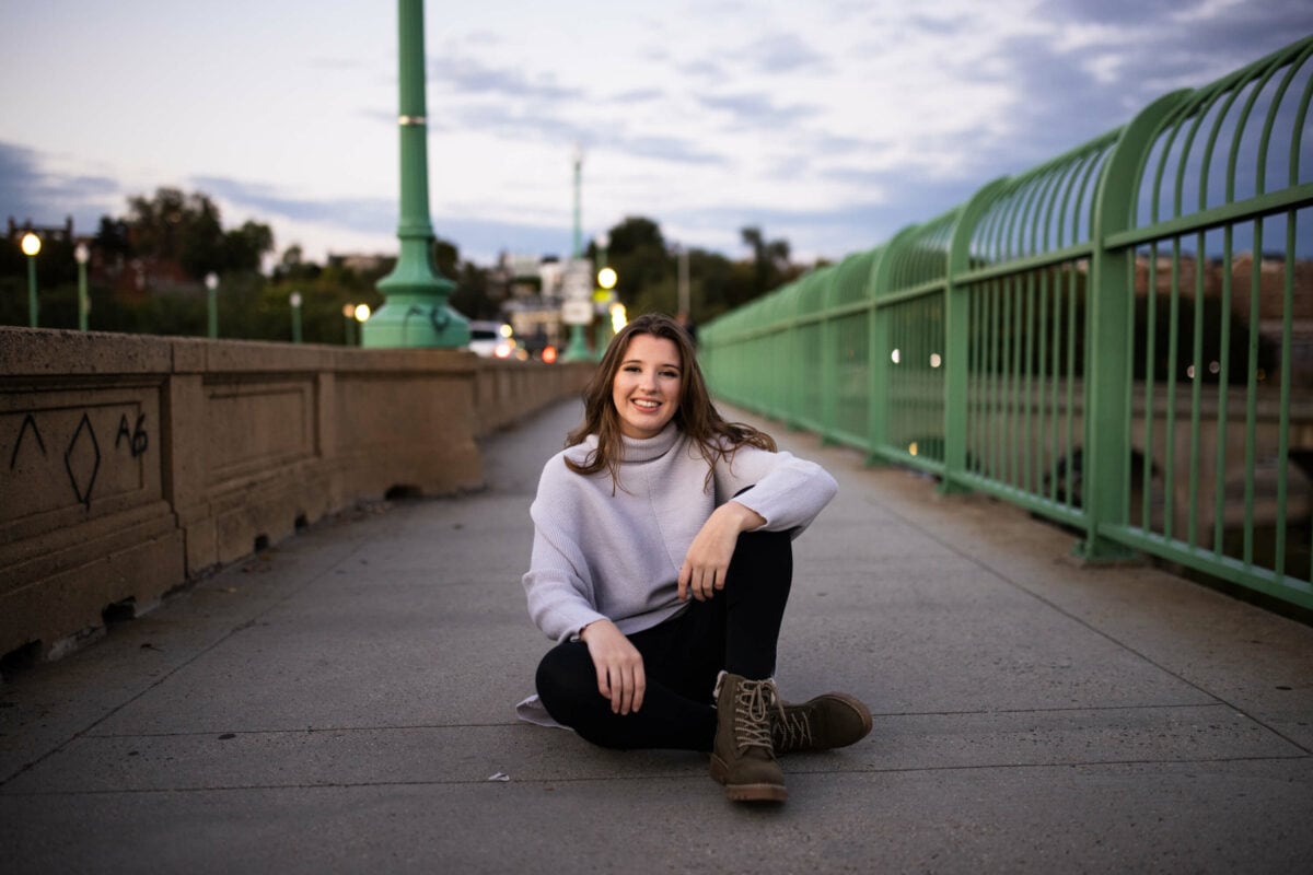 girl sitting on bridge Tips for Your Senior Portrait Session