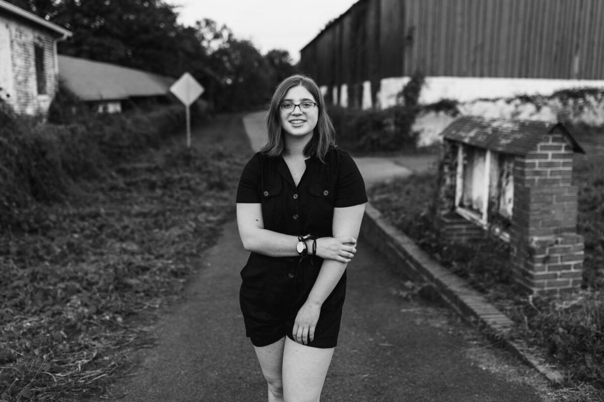 girl standing in front of rugged building smiling