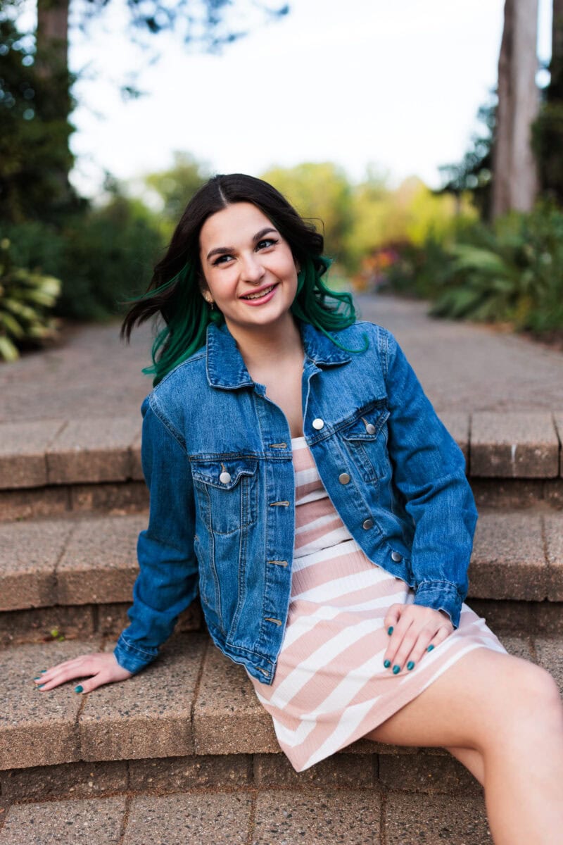 spring senior session with girl sitting on stairs in garden