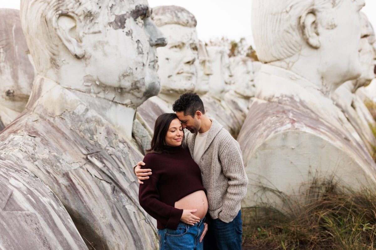 pregnant mom standing with husband at outdoor session