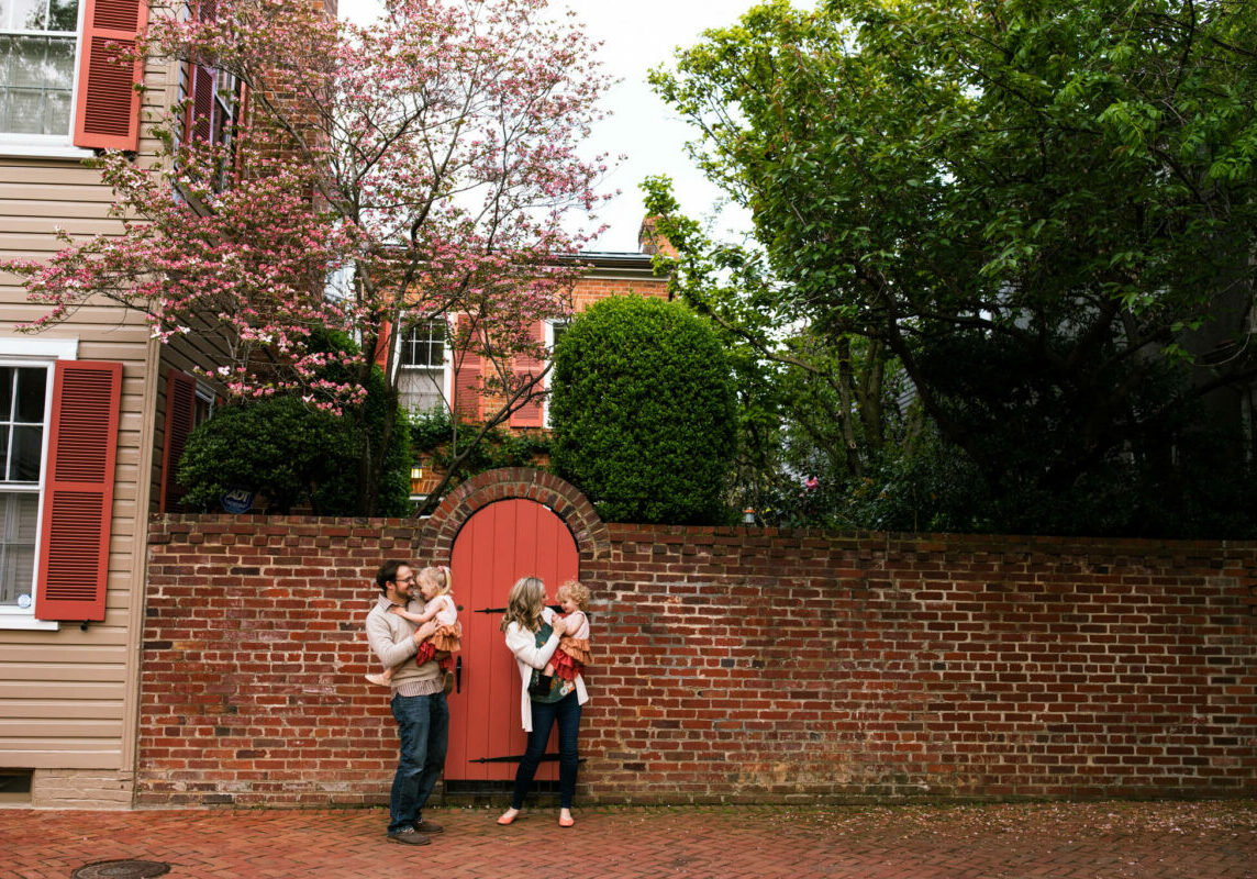 family in old town Alexandria under blooming dogwood tree